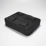 Svart packkub sedd underifrån med fyra kardborrefästen på undersidan.