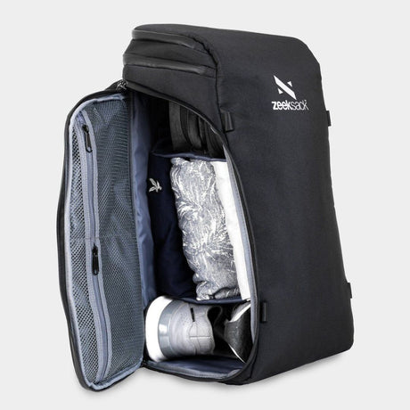 A black backpack opened from the side and packed with shoes and clothing.