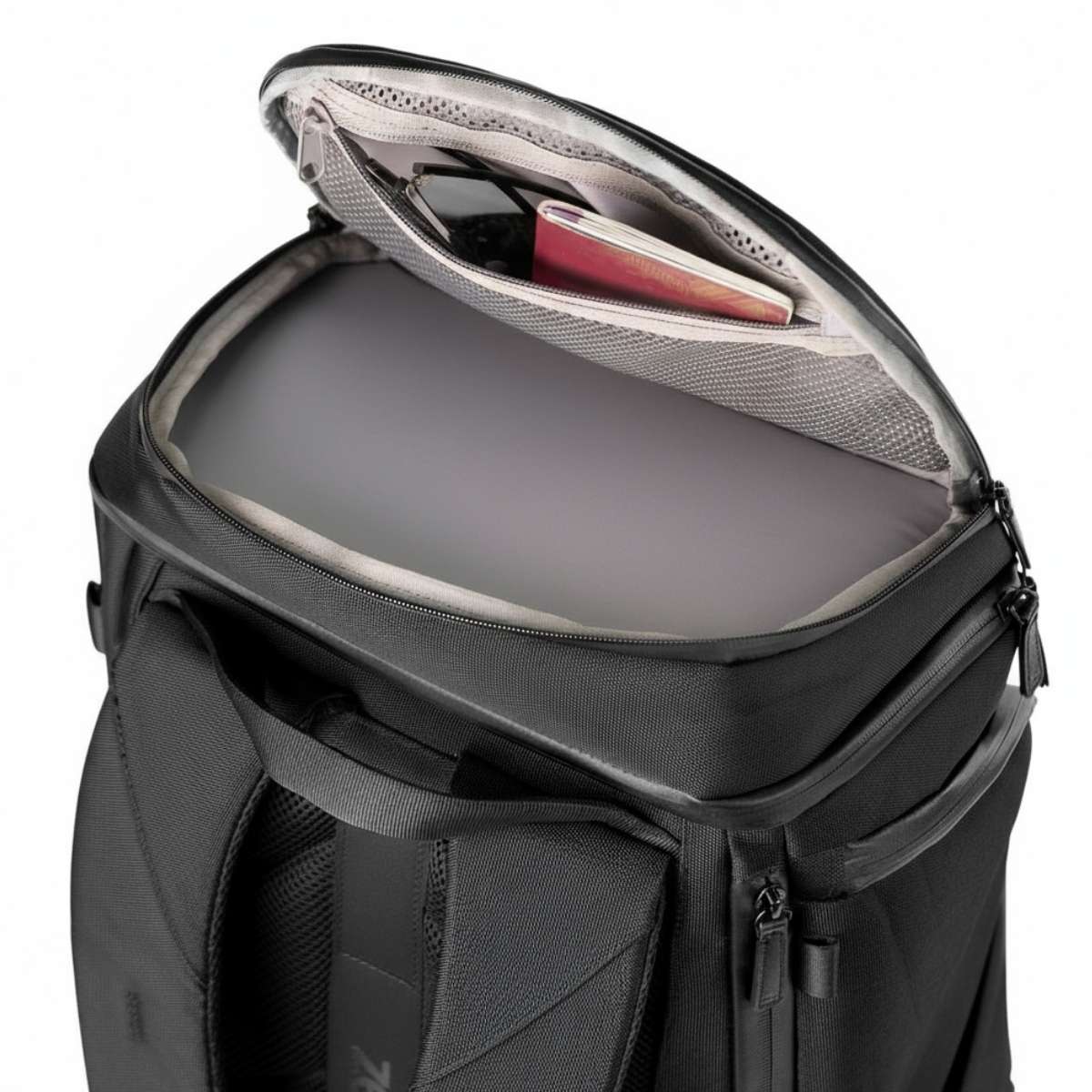 Top-down close-up of a black backpack with the top compartment open, showing the organized interior.