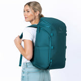 Woman wearing a petrol blue backpack.